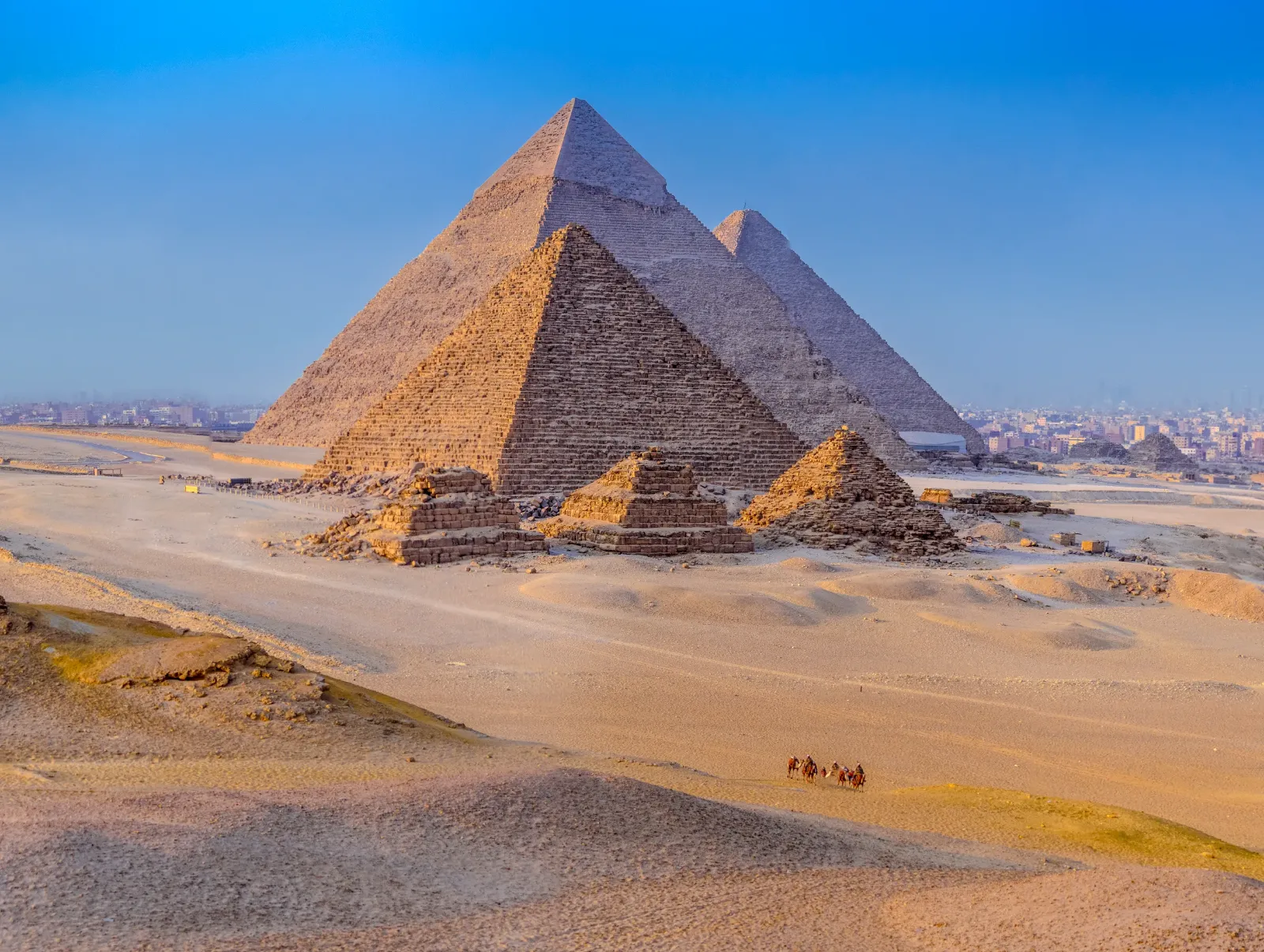 Es sind die Pyramiden von Gizeh in Ägypten vor einem etwas diesigen Himmel zu sehen.