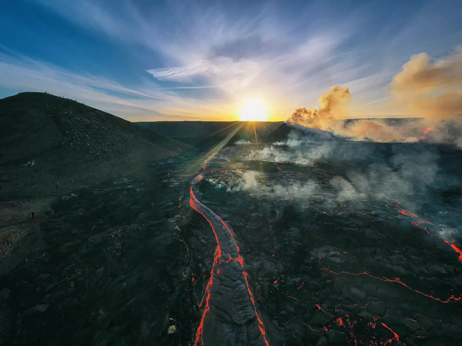 Lavafluss im Vulkan mit rauchenden Wolken und Sonnenstrahlen.