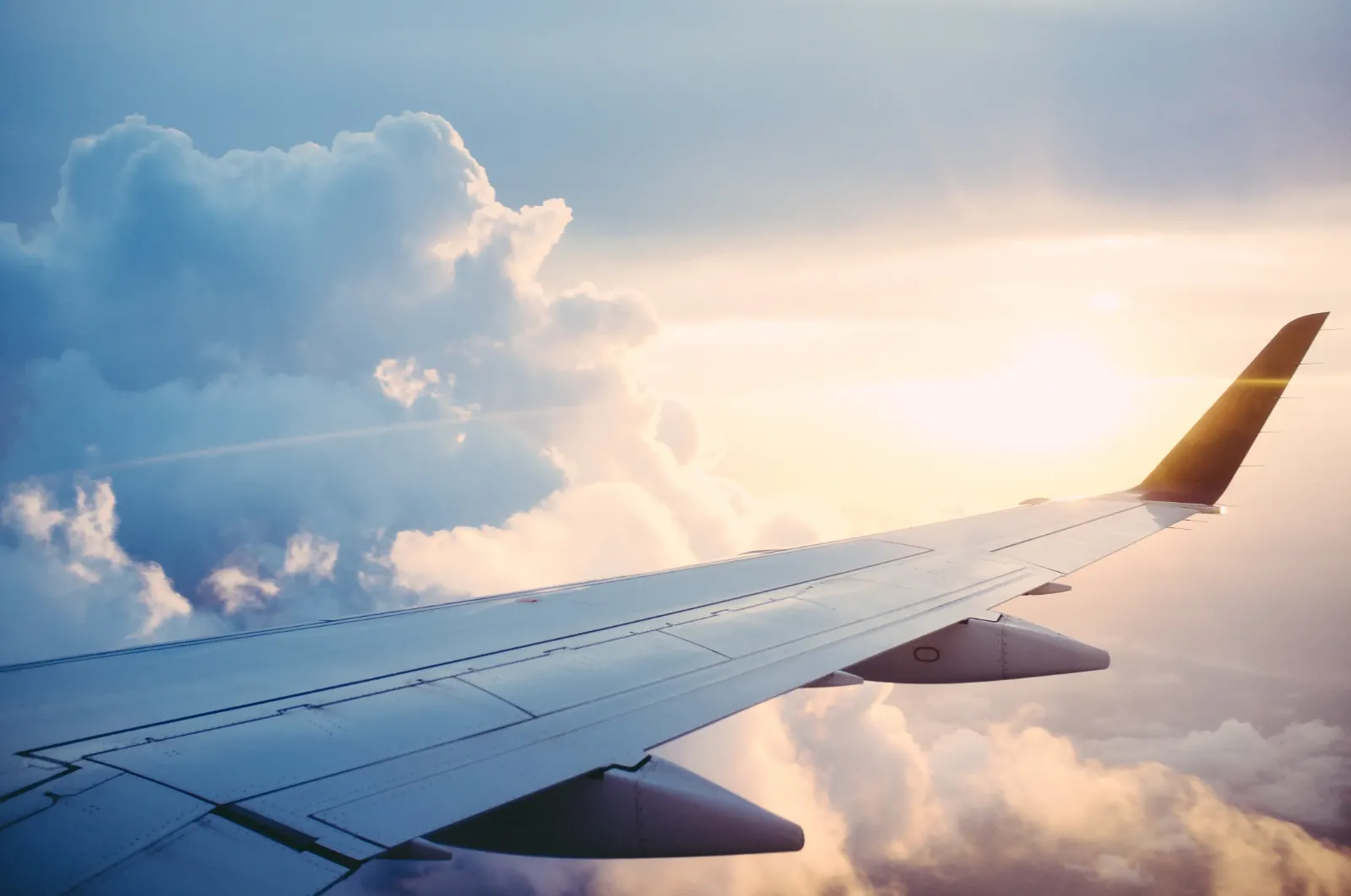 Blick auf den Flügel eines Flugzeugs über den Wolken