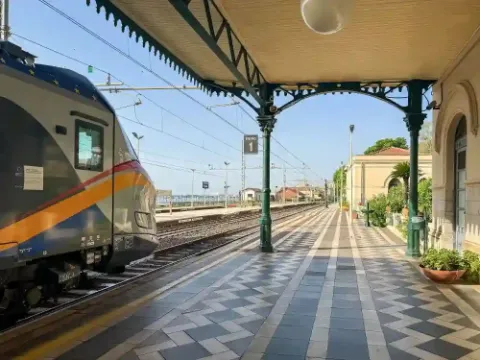 Blick auf Gleis 1 eines historischen Bahnhofs mit einem wartenden Zug.