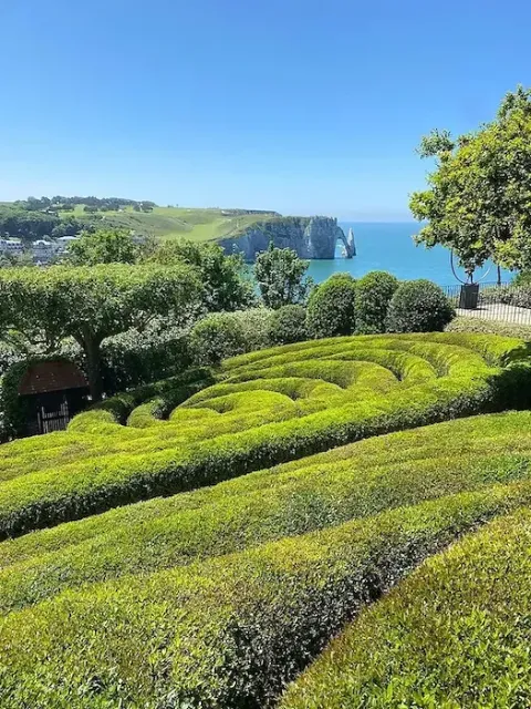 Eine grüne und hügelige Küstenlandschaft bei Etretat in der französischen Normandie.