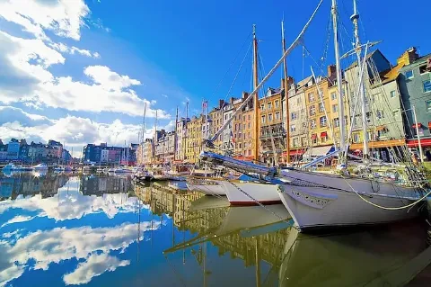 Boote im und Häuser am Hafen von Bonfleur in der französischen Region Normandie.