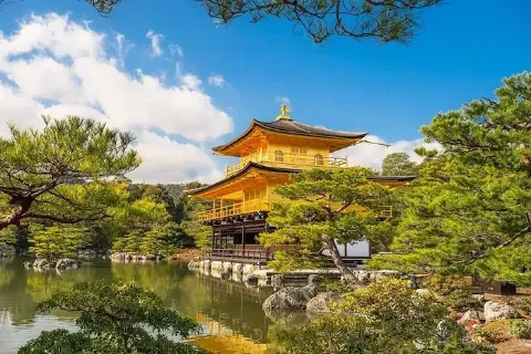 Der Goldene Pavillon Kinkaku-ji in Kyoto inmitten von Bäumen und an einem Teich gelegen.