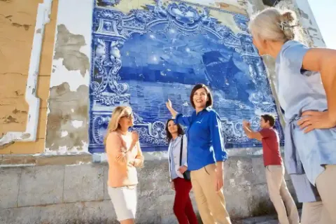 Eine Gruppe von Menschen die ein buntes Wandgemälde besichtigen.