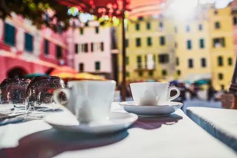 Kaffeetassen auf einer italienischen Piazza in Sonnenlicht.