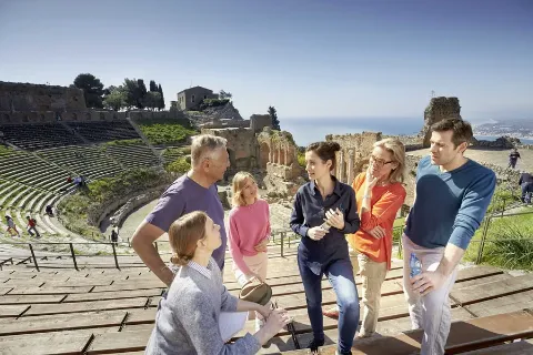 Gäste sind gespannt was Ihnen die Reiseleiterin über das Amphitheater erzählt, in dem sie sich befinden.