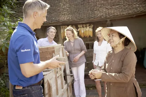 Reiseleiter moderiert eine Begegnung in Asien.