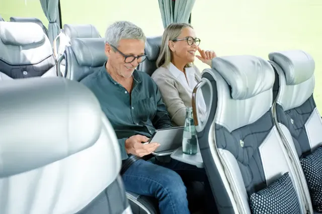Ein Paar hat Spaß und entspannt sich während einer Busfahrt.