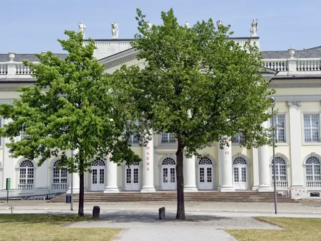 Frontansicht des Fridericianums in Kassel, im Vordergrund zwei Laubbäume.