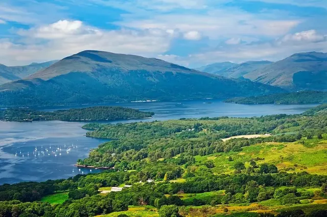Ein Panoramablick mit grünen Hügeln, Seen, Inseln und Segelbooten im nordenglischen Lake District.