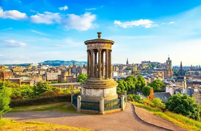 Ein Panoramablick vom Carlton Hill über die schottische Hauptstadt Edinburgh,  mit einem runden Monument mit Säulen im Vordergrund.