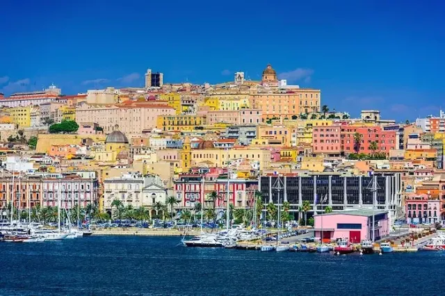 Die Altstadt und der Hafenfront von Cagliari, Hauptstadt der italienischen Insel Sardinien, bei sonnigem Wetter.