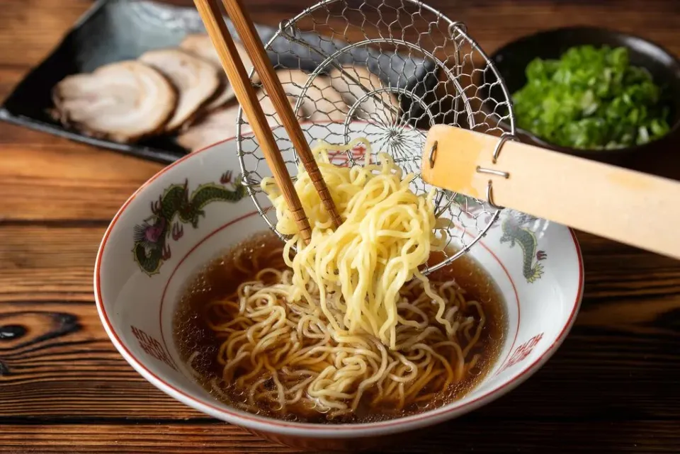 Asiatische Schüssel mit Nudel und Essstäbchen.