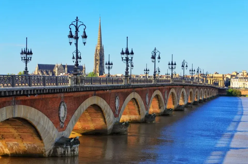 Die Pont de Pierre Brücke in Bordeaux über den Fluss Garonne bei blauem Himmel.