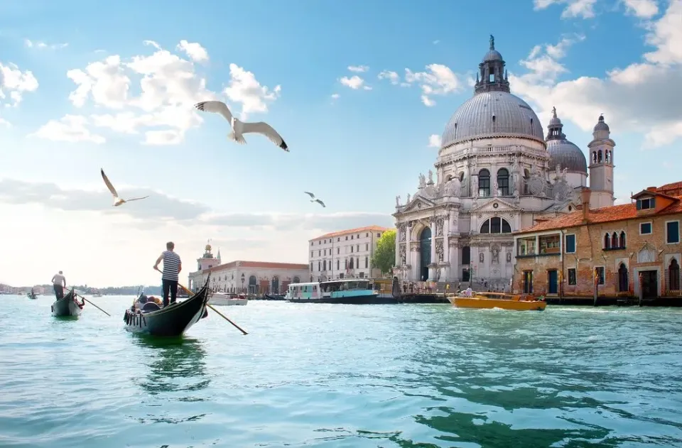 Die Kirche Santa-Maria-della-Salute am Wasser in Venetien mit Gondeln im Vordergrund.