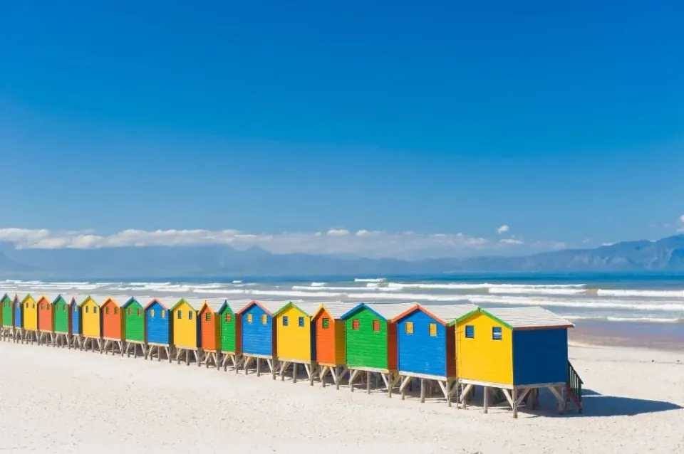 Bunte Hütten am Strand mit klarem blauem Himmel.