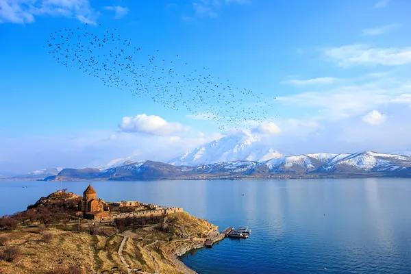 Der Vansee in der Osttürkei ist zusammen mit einer Landzunge im Vordergrund und dem Bergpanorama im Hintergrund zu sehen.