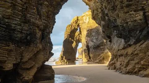 Der Strand der Kathedralen von Ribadeo präsentiert sich uns auf unserer Gruppenreise mit Studiosus bei Ebbe besonders eindrucksvoll: Wind und Wetter meißelten an den Felstoren, die sich wie gotische Strebebögen an die Küste anlehnen.