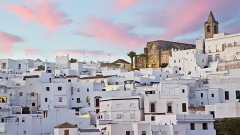Auf unserer Rundreise durch Andalusien für Singles und Alleinreisende erfreuen wir uns an den terrassenförmig angelegten Weißen Häusern in Vejer de la Frontera mit der Kirche ganz oben, hier im Abendlicht.