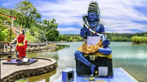 Bei unserer Studiosus-Reise für Singles und Alleinreisende auf Mauritius tauchen wir ein in den Hinduismus, der auf der Insel weit verbreitet ist. In Grand Bassin erkunden wir verschiedene Shiva-Statuen.