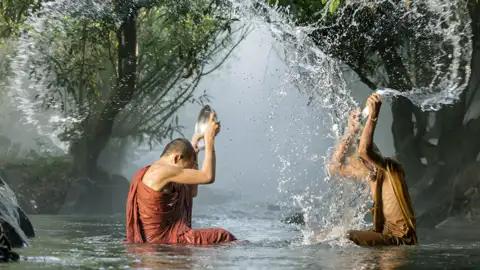 Der Buddhiusmus begegnet uns bei der Rundreise in Thailand immer wieder. Hier waschen sich buddhistische Mönche in einem Fluss.