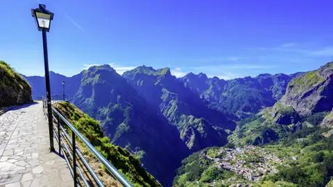 Genießen Sie den Panoramablick auf ein Bergtal mit einer kleinen Stadt im Tal.