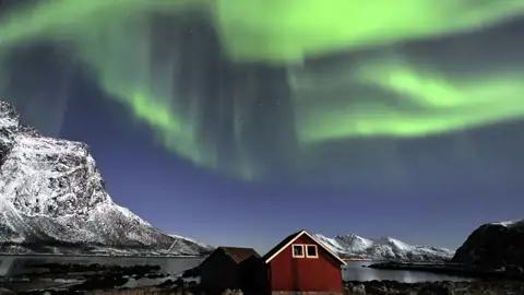 Polarlichter tanzen zwischen den Fjorden und Berggipfeln