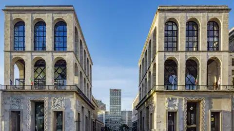 Auf unserer Eventreise mit Studiosus nach Italien bewundern wir symmetrische Fassaden des Palazzo dell’Arengario in Mailand mit großen Rundbogenfenstern und Blick auf die Torre Velasca.
