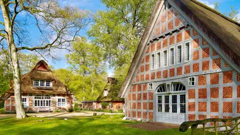 Ein traditionelles niedersächsisches Fachwerkhaus mit Reetdach im Künstlerdorf Worpswede, Ausflugsziel einer Studienreise mit Studiosus.