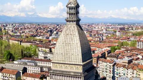 Panoramablick auf Turin mit der markanten Kuppel der Mole Antonelliana vor der Kulisse der schneebedeckten Alpen, ein Highlight unserer Italien-Gruppenreise mit Studiosus.
