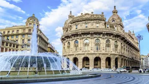 Der imposante Springbrunnen auf der Piazza De Ferrari in Genua vor prachtvollen Palazzi unter einem leicht bewölkten Himmel, welchen wir auf unserer Gruppenreise mit Studiosus bewundern.