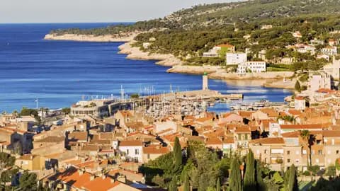 Panoramablick auf die Küstenstadt Cassis an der Côte d'Azur mit ihrem Hafen, den Häusern mit Ziegeldächern und dem Mittelmeer, ein Ausblick, den wir auf unserer Gruppenreise mit Studiosus genießen.