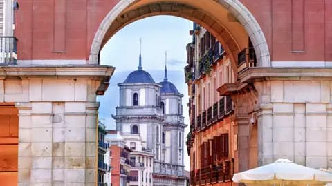 Studienreise nach Madrid: Der Blick durch den Arco de Cuchilleros der Plaza Mayor auf die Colegiata de San Isidro.