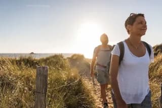 Ein Paar beim Wandern am Strand bei Sonnenuntergang.