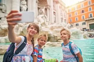Kinder machen ein Selfie am Trevi-Brunnen in Rom.