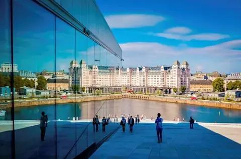 Es ist die Oper in Oslo zu sehen, die sich in der Glasscheibe eines anderen, neuen Gebäudes spiegelt.