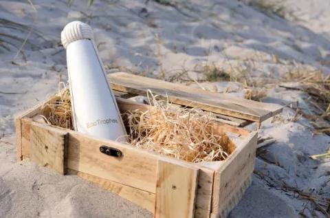 Holzkiste mit einer wieder verwendbaren Flasche in natürlicher Umgebung