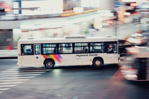 Ein Stadtbus auf einer urbanen Kreuzung mit Lichtspuren.