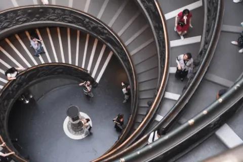 Menschen, die die Spiraltreppe im Vatikan hinuntergehen und fotografieren.