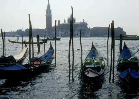 Blick auf Venedig mit Gondeln im Wasser und historischen Gebäuden im Hintergrund.