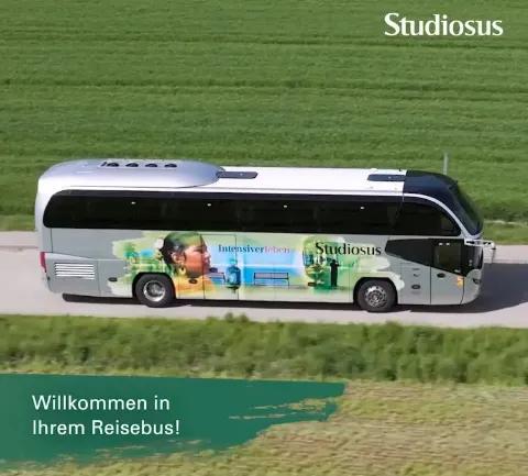 Der Standard-Reisebus von Studiosus fährt auf einer Landstraße umgeben von Natur.