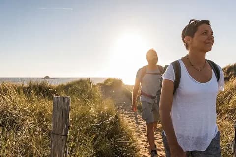 Ein Paar beim Wandern am Strand bei Sonnenuntergang.