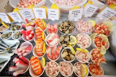 Eine bunte Auswahl an frischen Meeresfrüchten in Schalen.