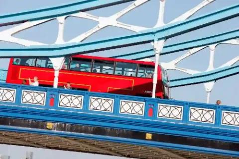 Ein Roter Doppeldeckerbus auf einer Brücke in London.