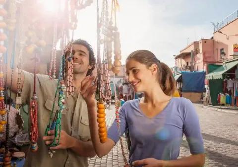 Zwei Personen, die auf einem Markt Schmuck betrachten.