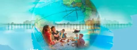 Eine Gruppe genießt gemeinsam eine Mahlzeit mit einem Globus und einem Gewässer im Hintergrund.