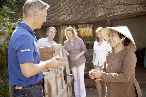 Reiseleiter moderiert eine Begegnung in Asien.