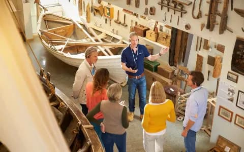 Der Reiseleiter erklärt den Gästen im Skogar-Museum etwas über die nordische Schiffsbaukunst.