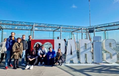 Gruppe von Azubis vor einem Paris-Schild auf einer Aussichtsplattform.
