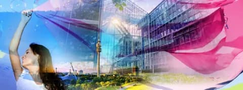 Frau, die ein Tuch im Freien schwenkt, mit einem modernen Gebäude und der Stadt München im Hintergrund.